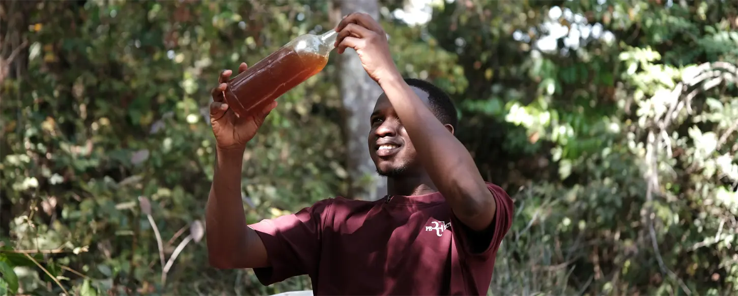 Un porteur de projet de Garambé examine une bouteille de production locale